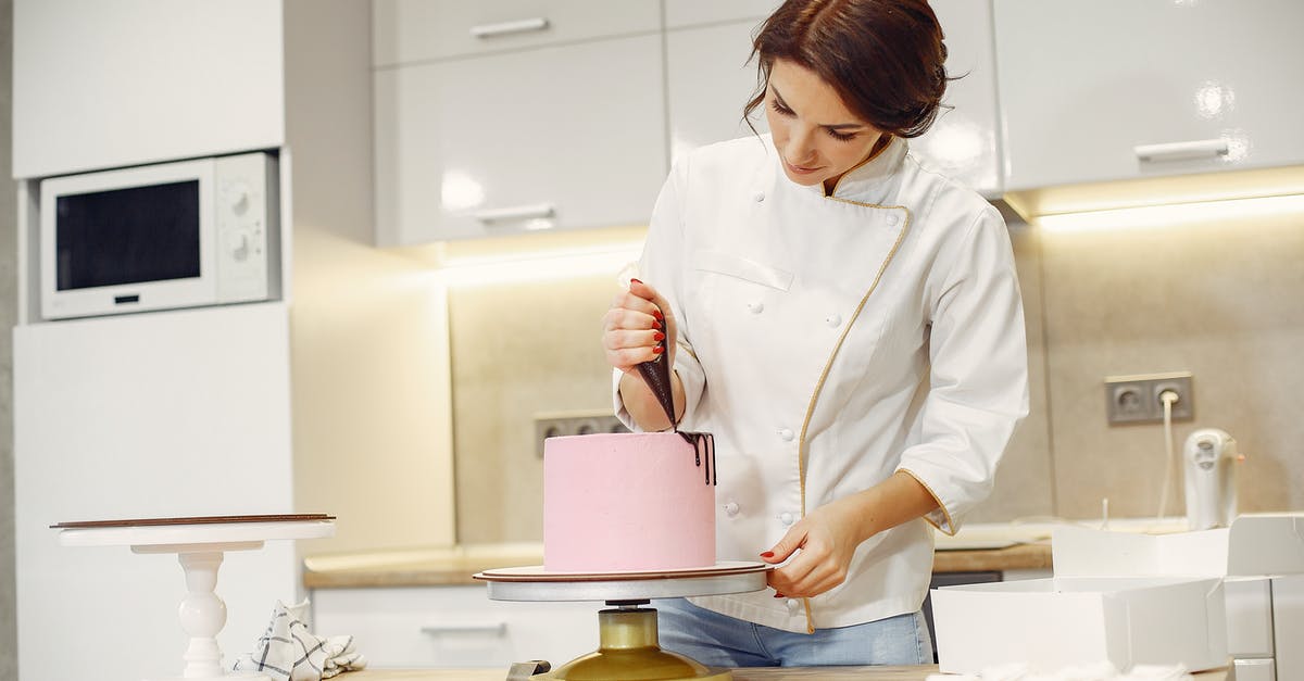How to convert a chocolate fudge frosting recipe to white chocolate? - Concentrated female pastry cook decorating cake with pleasure in modern restaurant How to convert a chocolate fudge frosting recipe to white chocolate? - Concentrated female pastry cook decorating cake with pleasure in modern restaurant