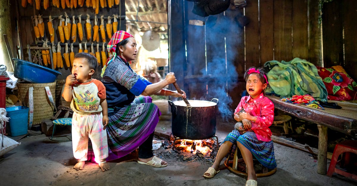 How to cook baby octopus? - Ethnic mother preparing food against crying girl and baby indoors How to cook baby octopus? - Ethnic mother preparing food against crying girl and baby indoors