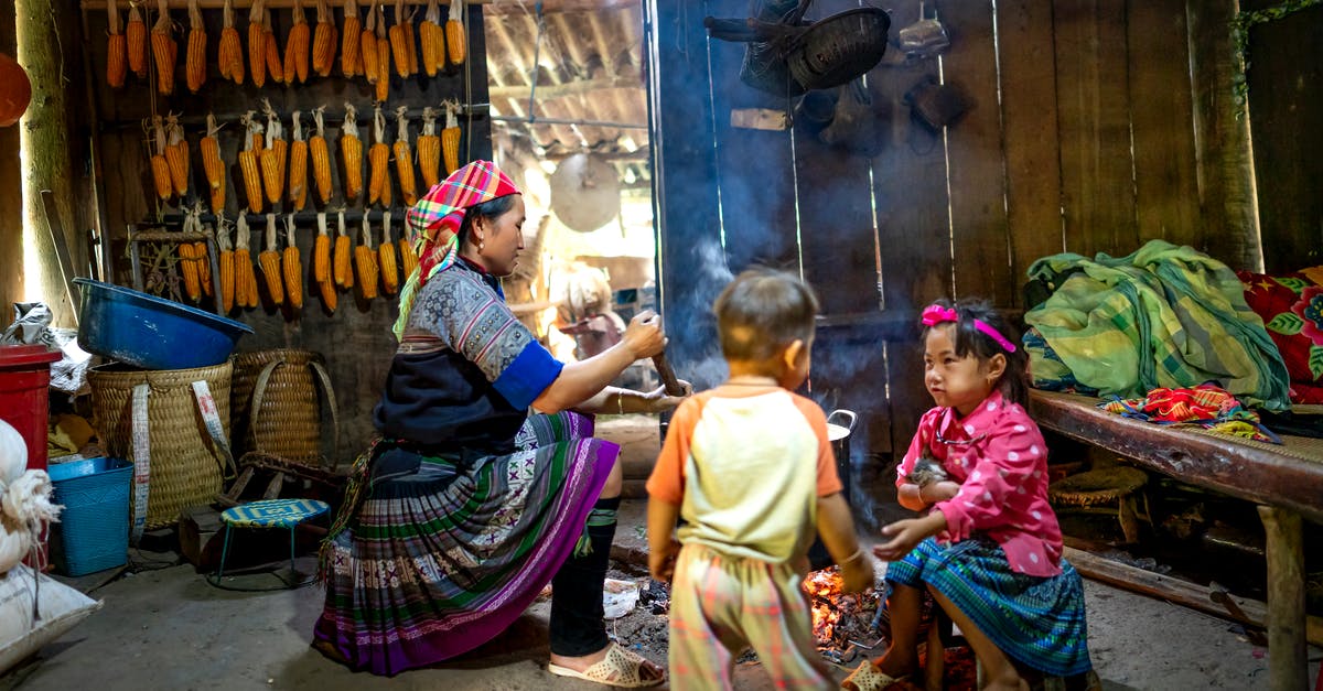 How to cook baby octopus? - Ethnic mom stirring food in pot against girl speaking with anonymous toddler brother in poor house How to cook baby octopus? - Ethnic mom stirring food in pot against girl speaking with anonymous toddler brother in poor house