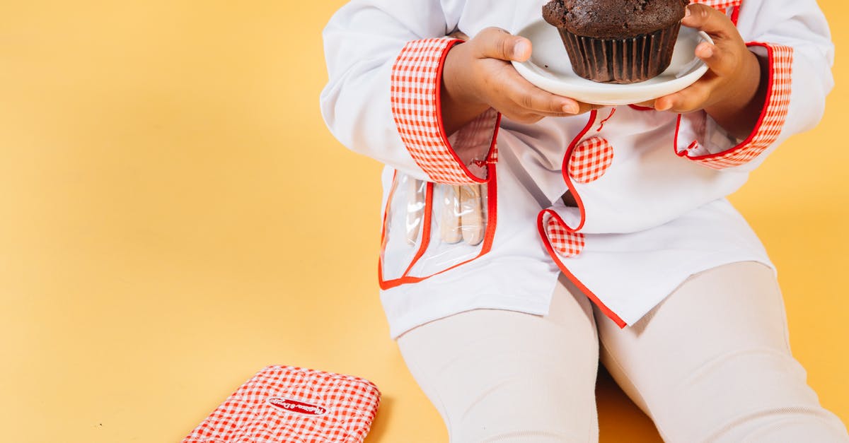 How to cook Brussells Sprouts and sweet potates in one oven? - Crop anonymous ethnic little girl wearing cook uniform sitting with baked cupcake near oven glove against yellow background How to cook Brussells Sprouts and sweet potates in one oven? - Crop anonymous ethnic little girl wearing cook uniform sitting with baked cupcake near oven glove against yellow background