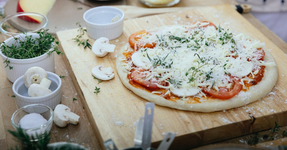 How to cook Parmesan Cheese into a broth without making globs? - From above of dough with tomatoes and champignons topped with cheese prepared for pizza on wooden board How to cook Parmesan Cheese into a broth without making globs? - From above of dough with tomatoes and champignons topped with cheese prepared for pizza on wooden board