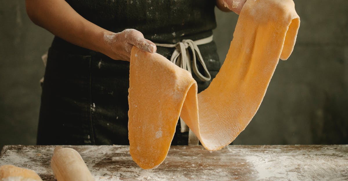How to cook the food such that no acrylamide is formed? - Woman with fresh dough near table in flour How to cook the food such that no acrylamide is formed? - Woman with fresh dough near table in flour