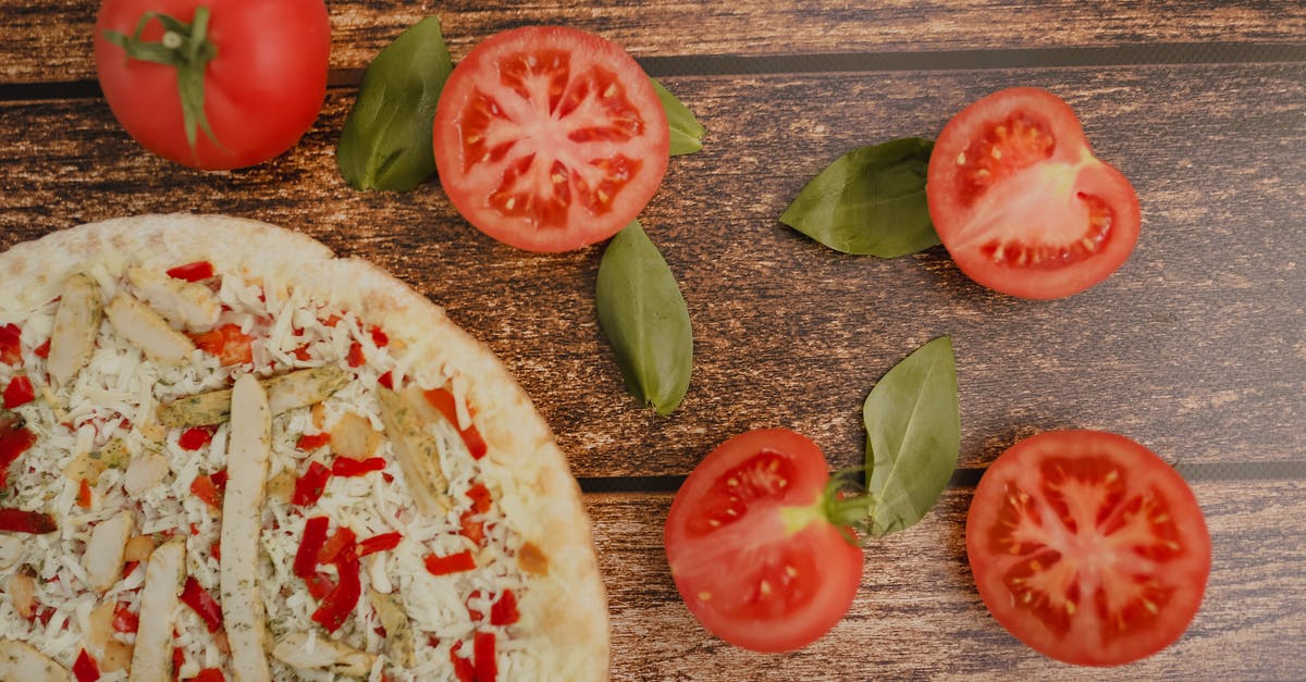 How to cut chicken without producing loud noises - Top view of tasty pizza with chicken slices and grated cheese near fresh cut tomatoes and basil leaves on wooden table How to cut chicken without producing loud noises - Top view of tasty pizza with chicken slices and grated cheese near fresh cut tomatoes and basil leaves on wooden table