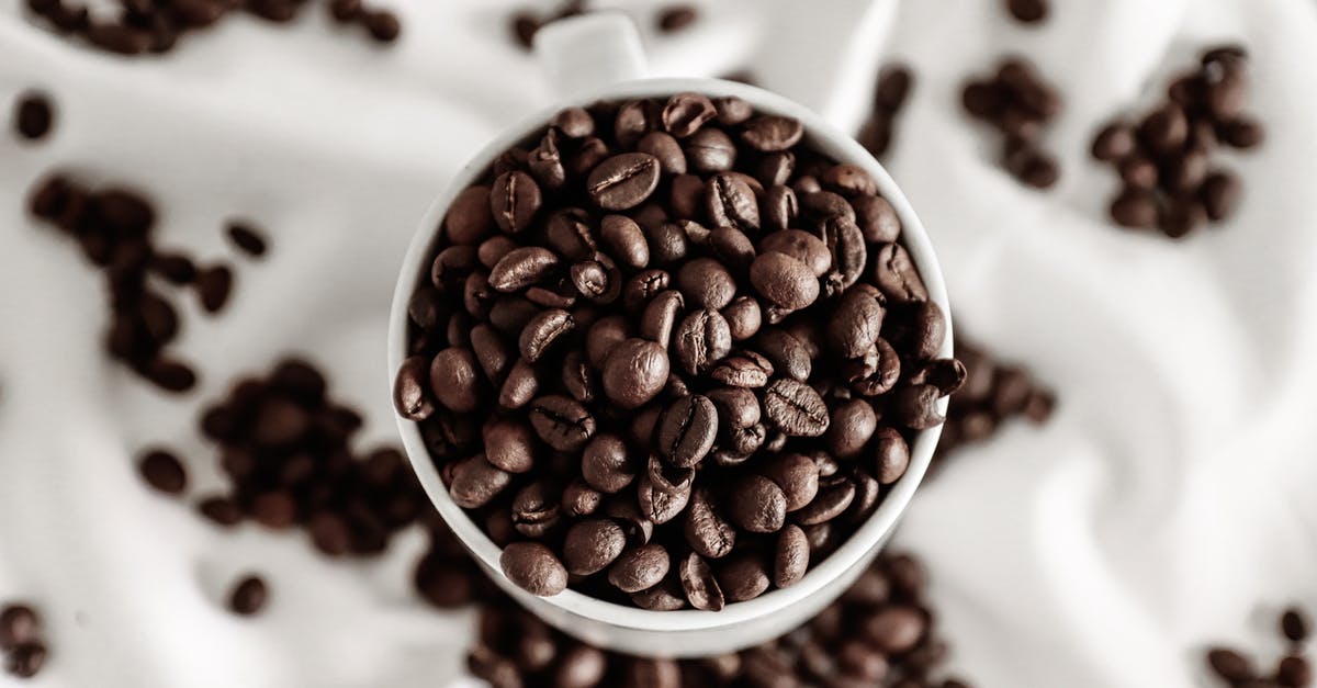 How to determine the grain of a fresh/ uncooked Arm Roast - Top view of coffee beans in cup near scattered grains on crumpled white cloth How to determine the grain of a fresh/ uncooked Arm Roast - Top view of coffee beans in cup near scattered grains on crumpled white cloth