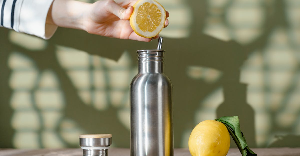 How to efficiently squeeze lemons by hand? - Person Squeezing Lemon on Stainless Steel Water Bottle