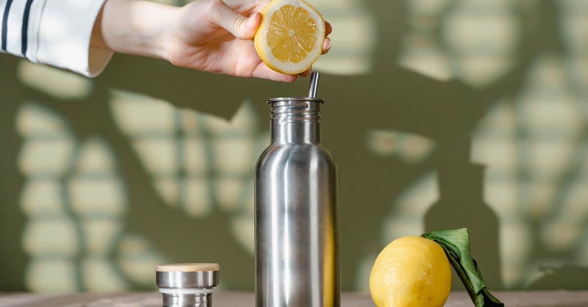 How to efficiently squeeze lemons by hand? - Person Squeezing Lemon on Stainless Steel Water Bottle How to efficiently squeeze lemons by hand? - Person Squeezing Lemon on Stainless Steel Water Bottle