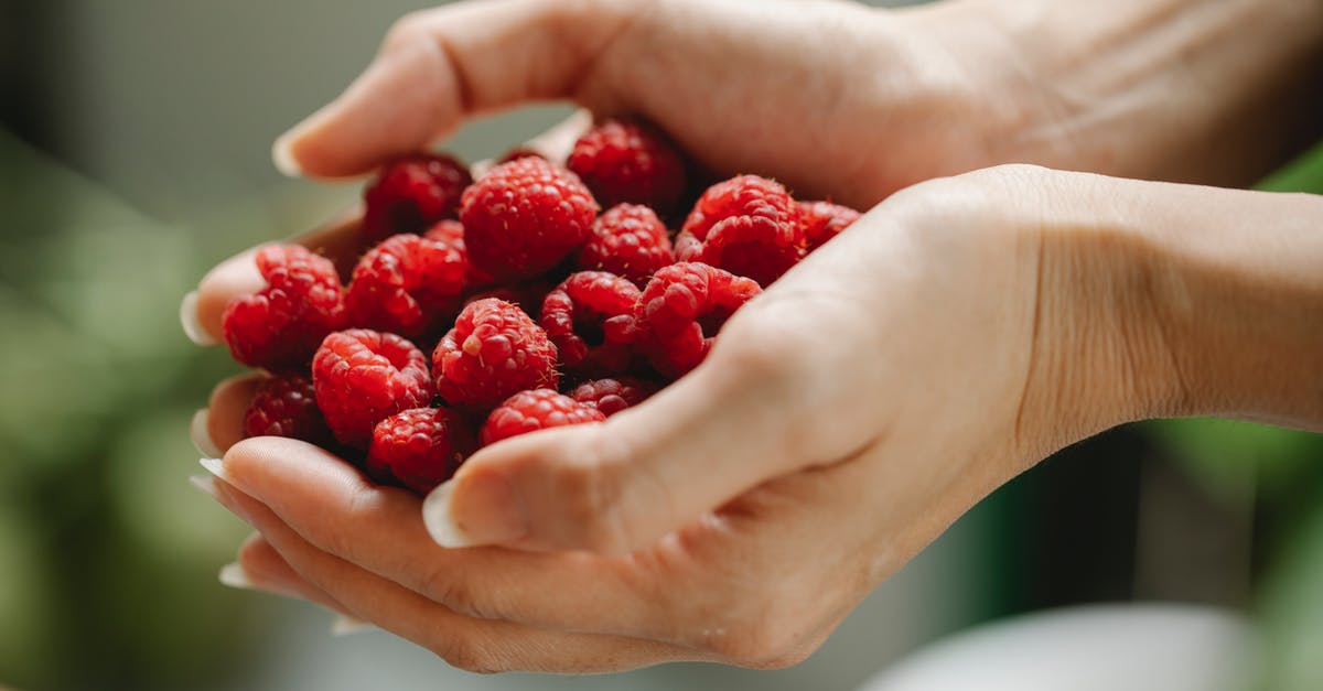 How to get raspberry flavor into a smoothie without seeds? - Crop woman with raspberries in hands How to get raspberry flavor into a smoothie without seeds? - Crop woman with raspberries in hands