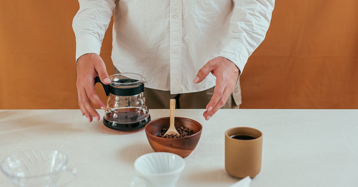 How to hand-select the perfect coffee bean? - Person in White Long Sleeve Shirt Holding Stainless Steel Container With Brown Liquid How to hand-select the perfect coffee bean? - Person in White Long Sleeve Shirt Holding Stainless Steel Container With Brown Liquid