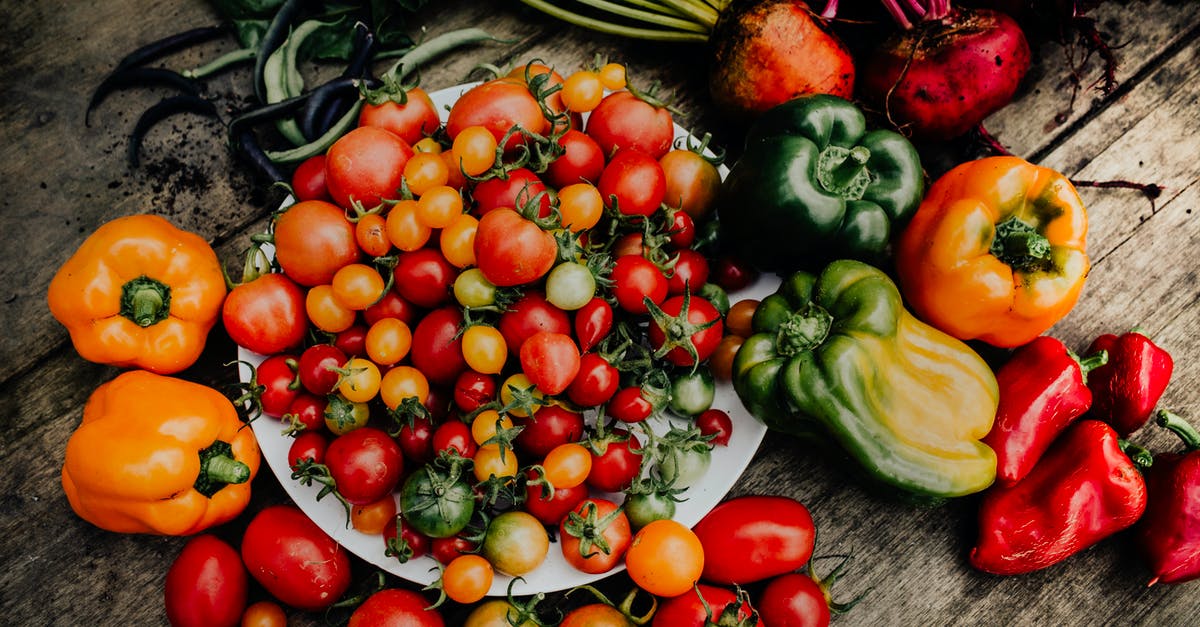 How to harvest peppers and tomatoes for later use in sauces without harming taste [duplicate] - Close-Up Shot of Tomatoes and Peppers on a Wooden Surface