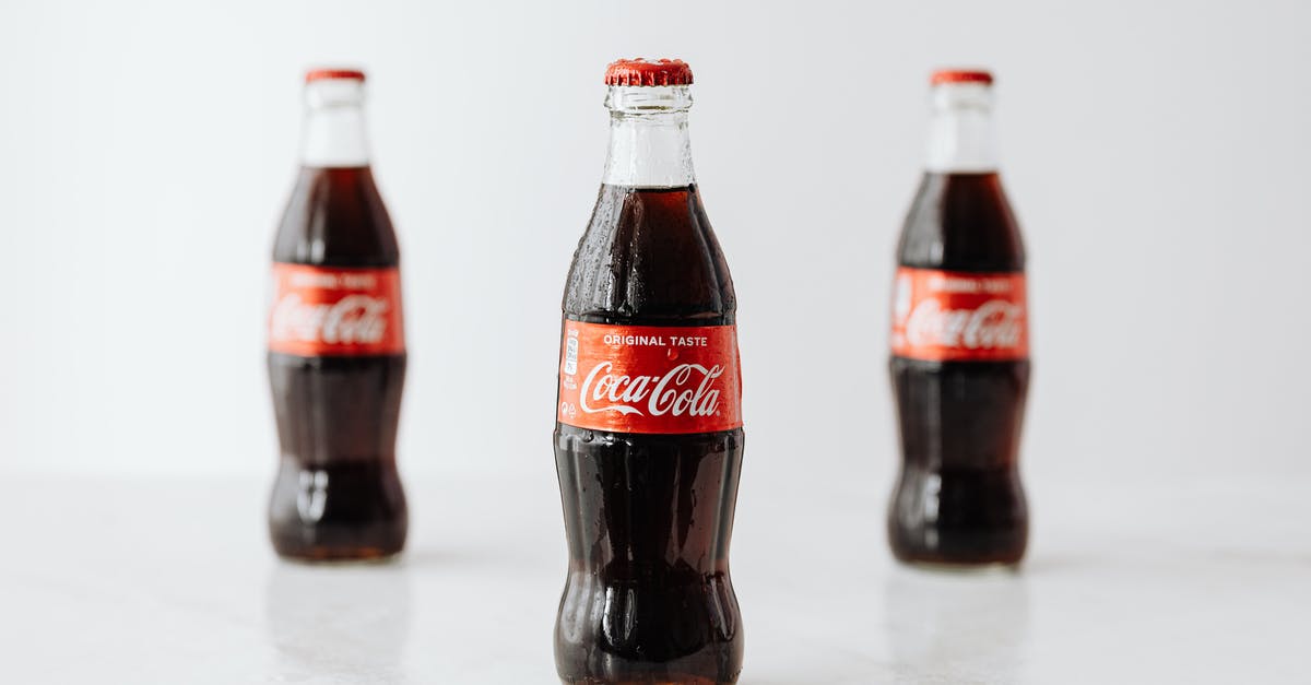 How to identify CTC tea? - Modern glass bottles of cold soda with red label placed on white reflective surface How to identify CTC tea? - Modern glass bottles of cold soda with red label placed on white reflective surface