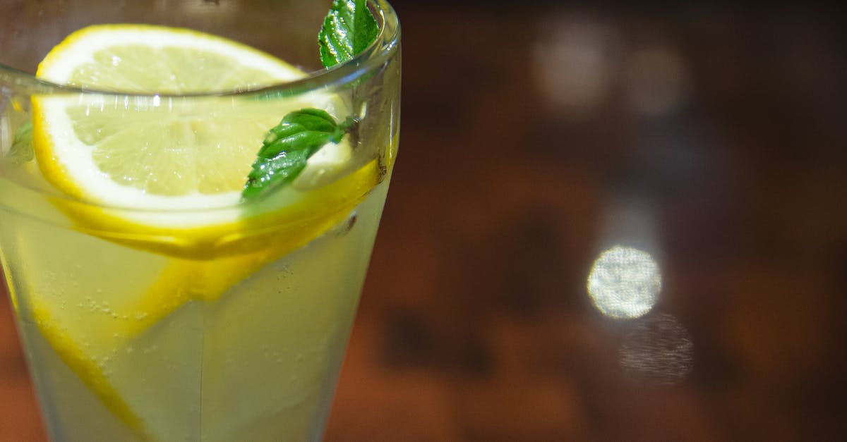 How to infuse flavours in alcohol? - Glass of cold sour lemonade served with lemon slices and fresh mint leaf on blurred wooden table How to infuse flavours in alcohol? - Glass of cold sour lemonade served with lemon slices and fresh mint leaf on blurred wooden table