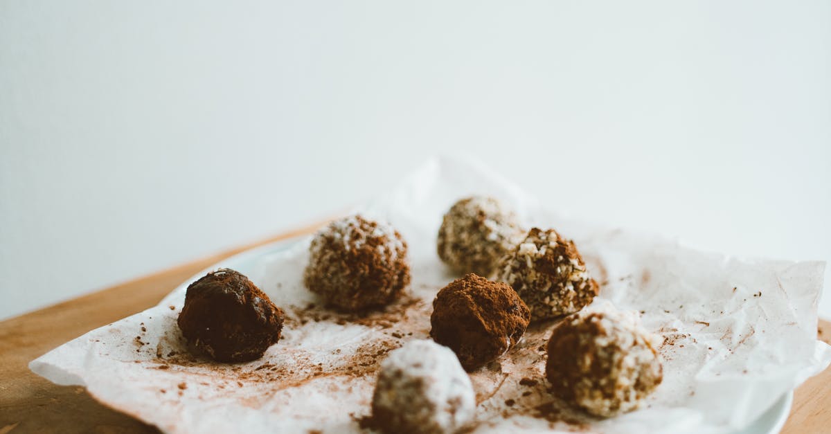 How to make a brittler, harder chocolate coating? - Chocolate Balls on Baking Paper on White Ceramic Plate How to make a brittler, harder chocolate coating? - Chocolate Balls on Baking Paper on White Ceramic Plate