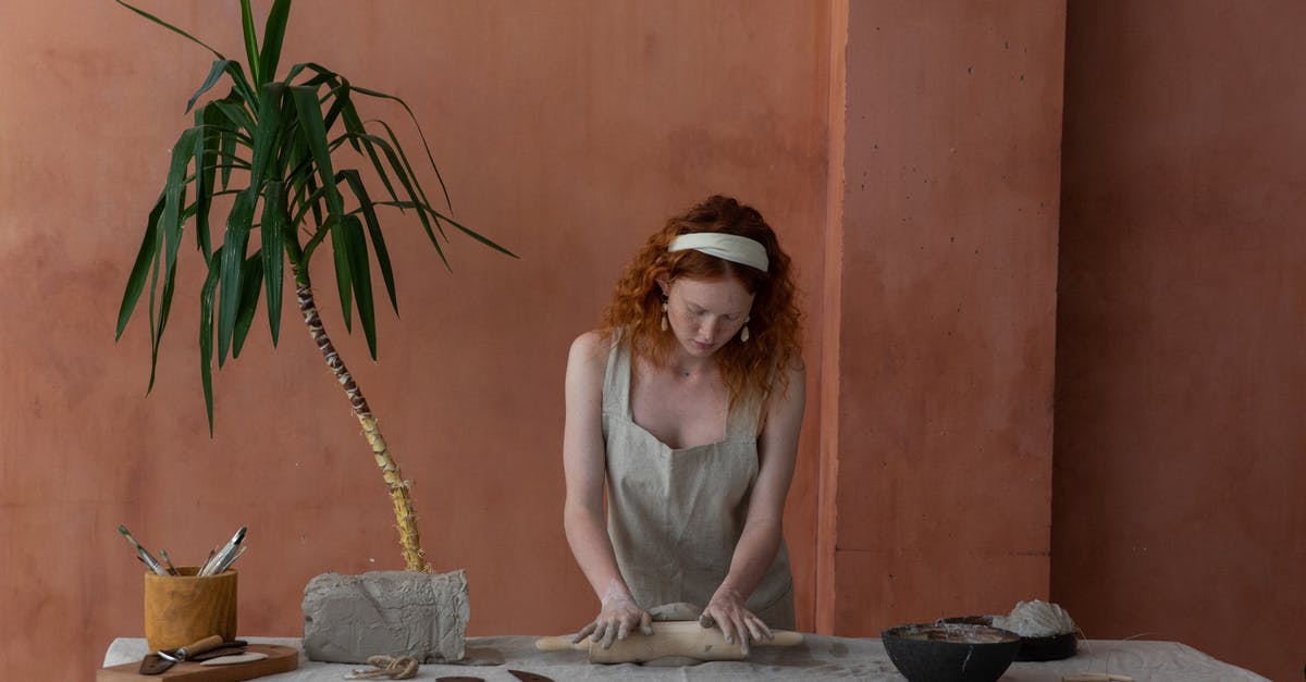 How to make a good pie dough like the industrial one? - Concentrated craftswoman rolling out clay slab in workshop How to make a good pie dough like the industrial one? - Concentrated craftswoman rolling out clay slab in workshop