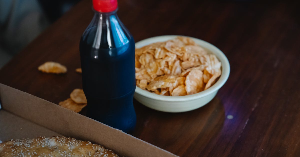 How to make crispy/dry potato chips/crisps? - From above of plastic bottle of soft drink between takeaway pizza with sesame seeds and crispy potato chips at home How to make crispy/dry potato chips/crisps? - From above of plastic bottle of soft drink between takeaway pizza with sesame seeds and crispy potato chips at home