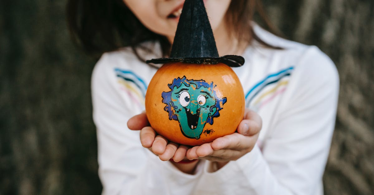 How to make pumpkin extract - Crop little girl in white dress showing colorful pumpkin painted for Halloween and decorated with paper hat How to make pumpkin extract - Crop little girl in white dress showing colorful pumpkin painted for Halloween and decorated with paper hat