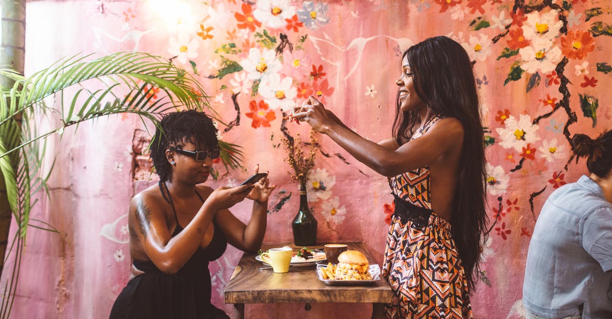 How to make restaurant style poppadoms - Side view happy African American females in stylish dresses taking photos on smartphones of freshly cooked food while having lunch in cozy cafe against painted wall How to make restaurant style poppadoms - Side view happy African American females in stylish dresses taking photos on smartphones of freshly cooked food while having lunch in cozy cafe against painted wall