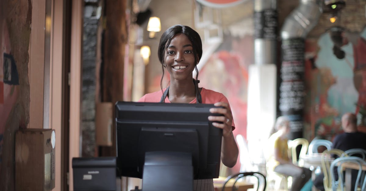 How to make restaurant style poppadoms - Positive young woman in uniform smiling while standing at counter desk in  cafe