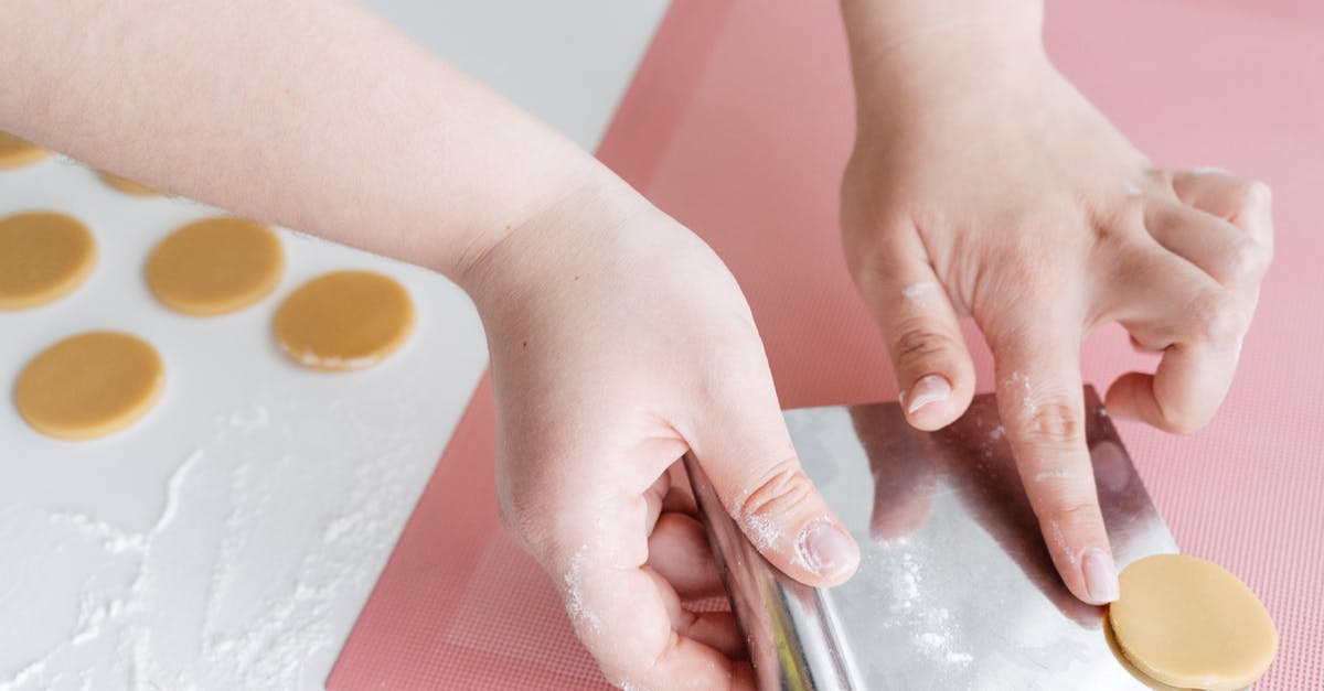 How to make softer biscuits? - Crop woman placing unbaked cookies on baking mat How to make softer biscuits? - Crop woman placing unbaked cookies on baking mat