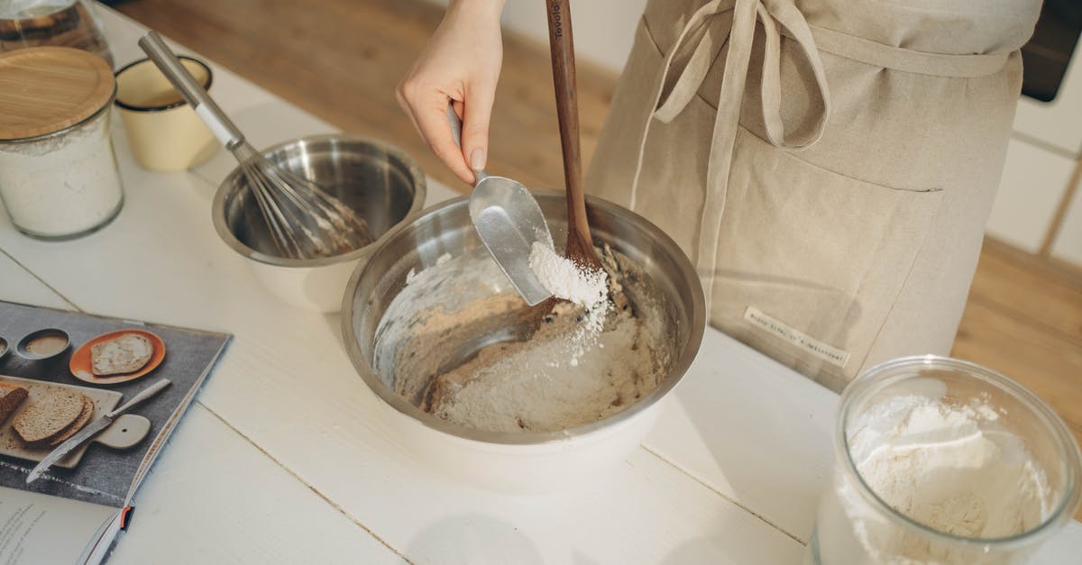 How to measure a dough humidity? - A Person Pouring Flour into the Bowl Using a Measuring Spoon
