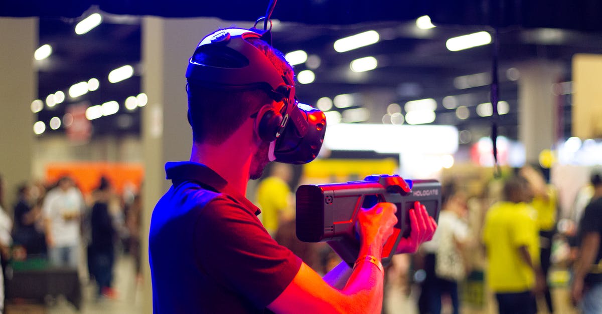 How to minimize splatter using an immersion blender? - Back view of young male in casual clothes and VR headset standing in spacious hall while testing device operation