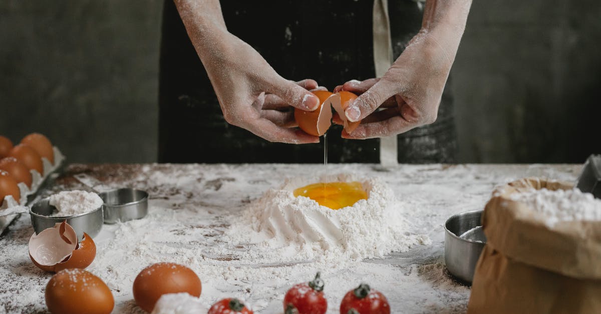 How to mix a spaghetti carbonara? - Crop anonymous chef preparing dough for recipe consisting of cherry tomatoes and spaghetti