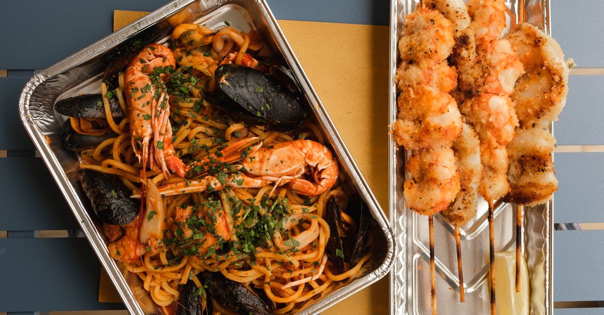 How to mix pasta and sauce evenly? - Delicious seafood dish on wooden table How to mix pasta and sauce evenly? - Delicious seafood dish on wooden table