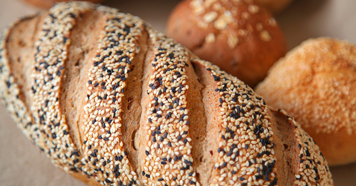 How to obtain the soft and pillowy texture in bread? - High angle of fresh baked bread with soft buns with sesame seeds served on surface in light place How to obtain the soft and pillowy texture in bread? - High angle of fresh baked bread with soft buns with sesame seeds served on surface in light place