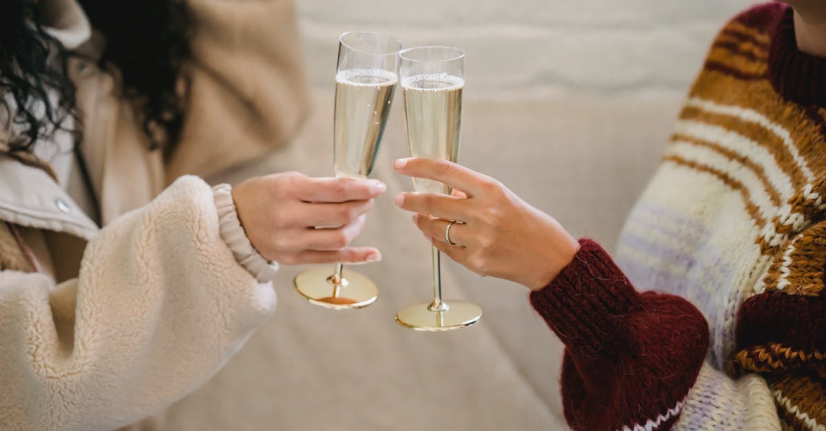 How to polish wine glasses if my hand cannot reach in? - Women clinking glasses with champagne in room