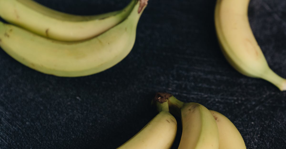 How to prepare an easy and fast snack rich in protein? [closed] - From above view of set of bunches of ripe unpeeled yellow bananas placed together on wooden dark shabby surface under bright light