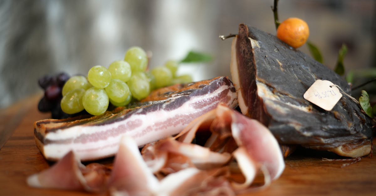 How to prepare Spanish Migas? - Delicious jamon with grapes served on table How to prepare Spanish Migas? - Delicious jamon with grapes served on table