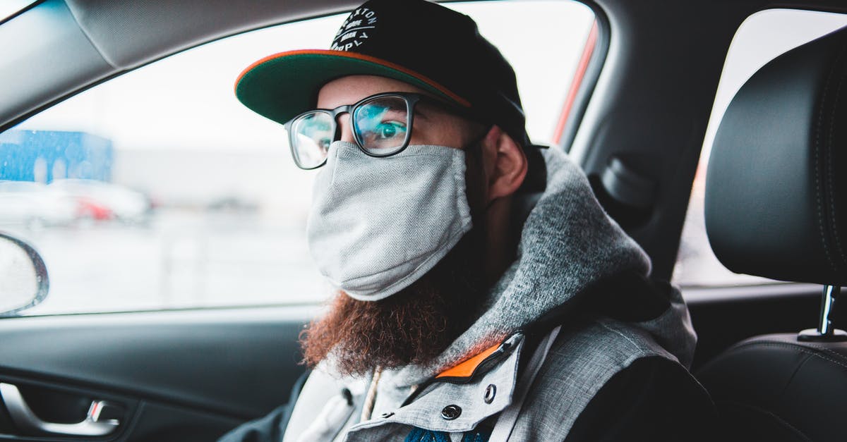 How to prevent flies sticking to hood fan lightbulb guard? - Young bearded hipster in glasses and protective mask wearing warm clothes and cap while sitting in car and looking away How to prevent flies sticking to hood fan lightbulb guard? - Young bearded hipster in glasses and protective mask wearing warm clothes and cap while sitting in car and looking away