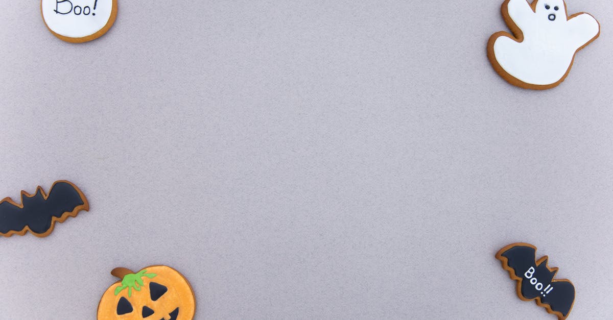 How to prevent sweet thick glaze/sauce from setting after cooling? - Top view of assorted gingerbread cookies with icing in different Halloween decoration shapes arranged on gray surface as frame