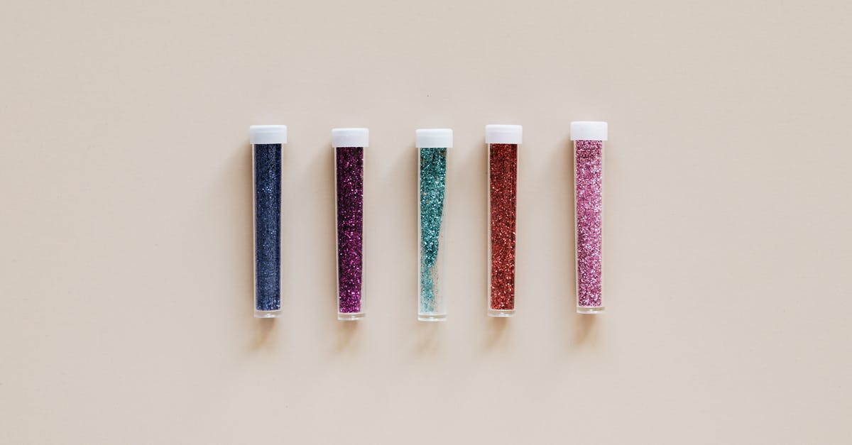 How to quickly fill cannelloni tubes with relatively dry mixture [duplicate] - From above of transparent narrow plastic tubes with white lids filled with small multicolored shiny beads on beige background