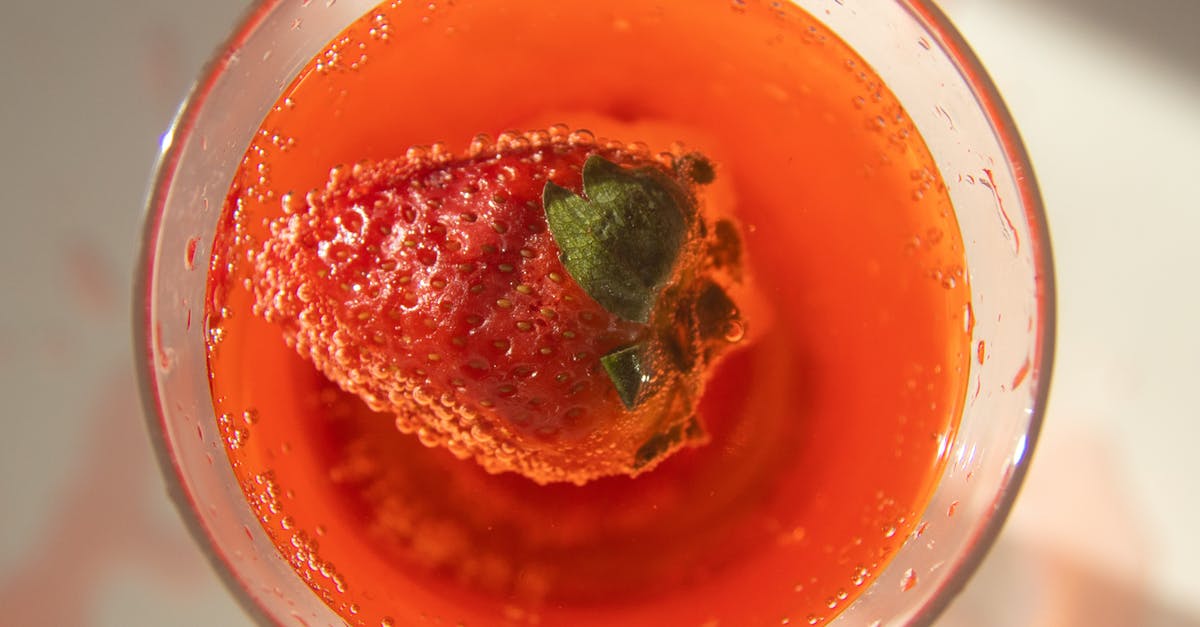How to remove alcohol taste from vanilla extract? - Top view of fresh red strawberry in glass of cold cocktail served on white table in sunlight How to remove alcohol taste from vanilla extract? - Top view of fresh red strawberry in glass of cold cocktail served on white table in sunlight