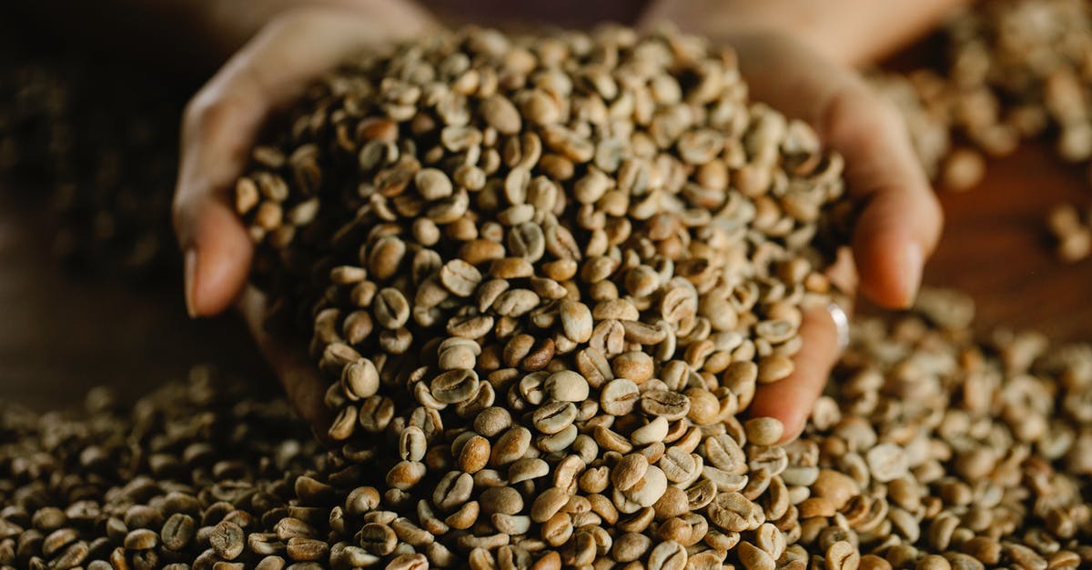 How to remove bad smell from kitchen? - From above of crop anonymous female demonstrating bunch of fresh raw beans of aromatic coffee scattered on wooden table How to remove bad smell from kitchen? - From above of crop anonymous female demonstrating bunch of fresh raw beans of aromatic coffee scattered on wooden table