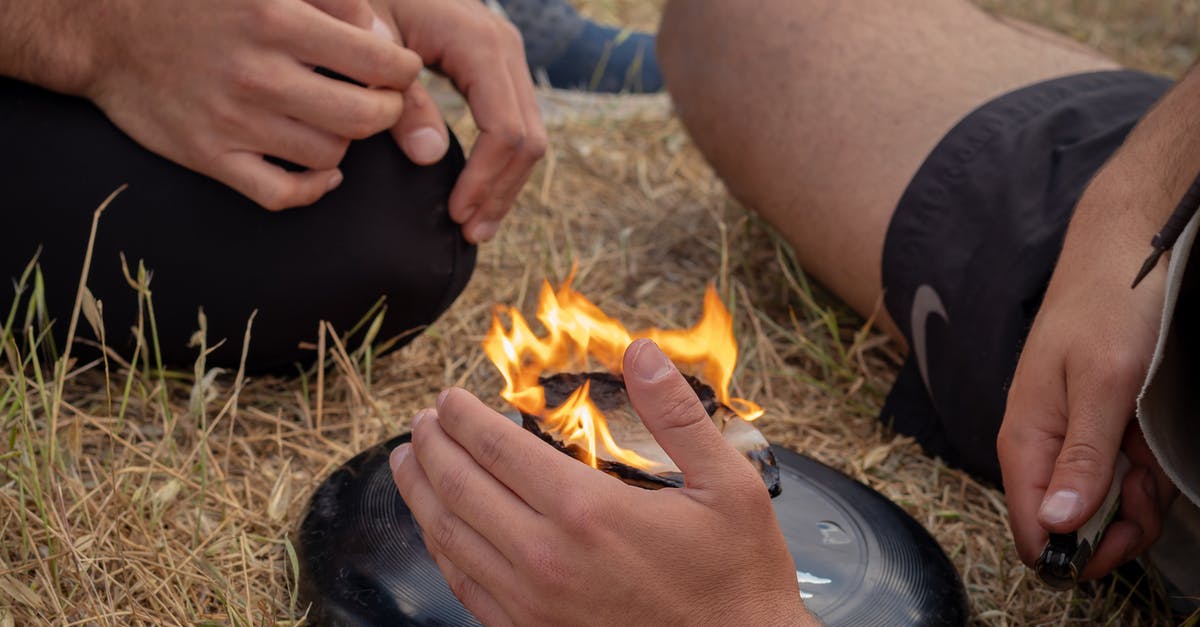 How to Remove Burned-on Grease from Stove - From above of crop anonymous men friends sitting near burning camping stove in nature in daytime