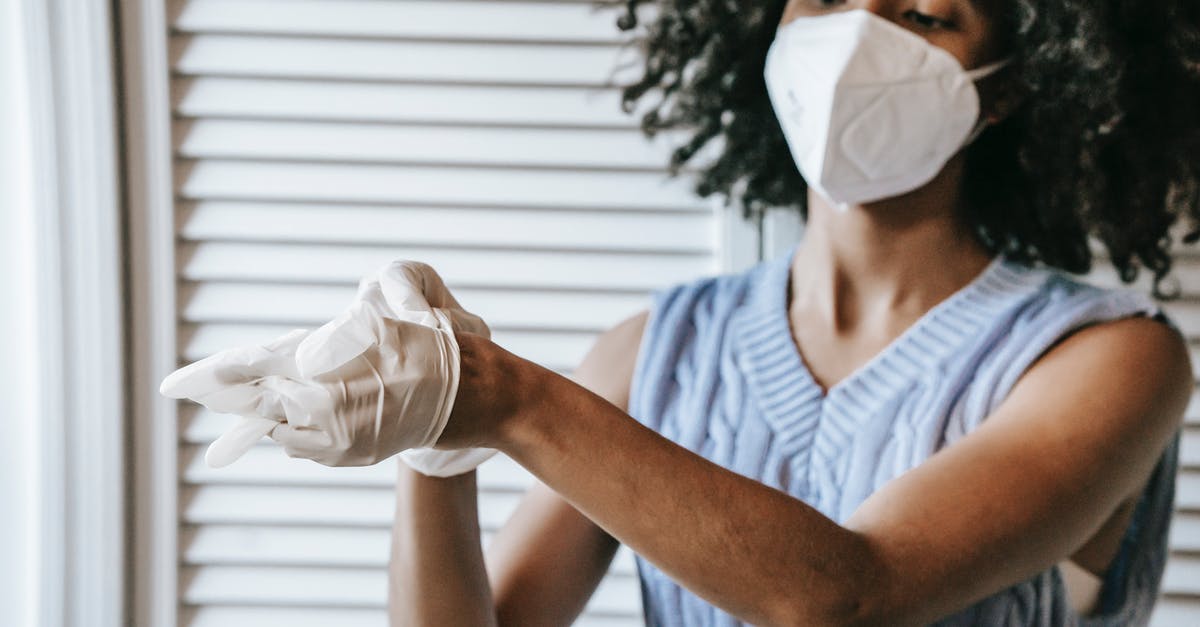 How to remove quinoa bitterness (with many restrictions) doing chapatis - Young African American female in white protective face mask putting of medical latex gloves How to remove quinoa bitterness (with many restrictions) doing chapatis - Young African American female in white protective face mask putting of medical latex gloves