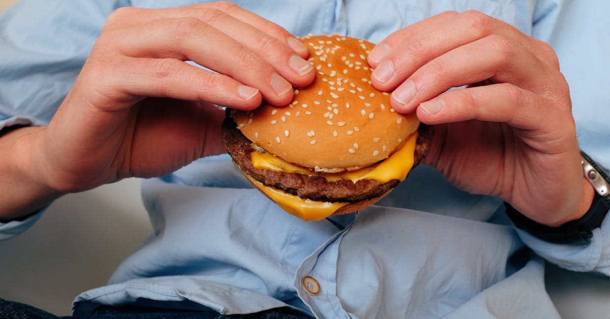 How to reproduce charcoal flavor in steaks and burgers from restaurants - Delicious burger in hands of unrecognizable man How to reproduce charcoal flavor in steaks and burgers from restaurants - Delicious burger in hands of unrecognizable man