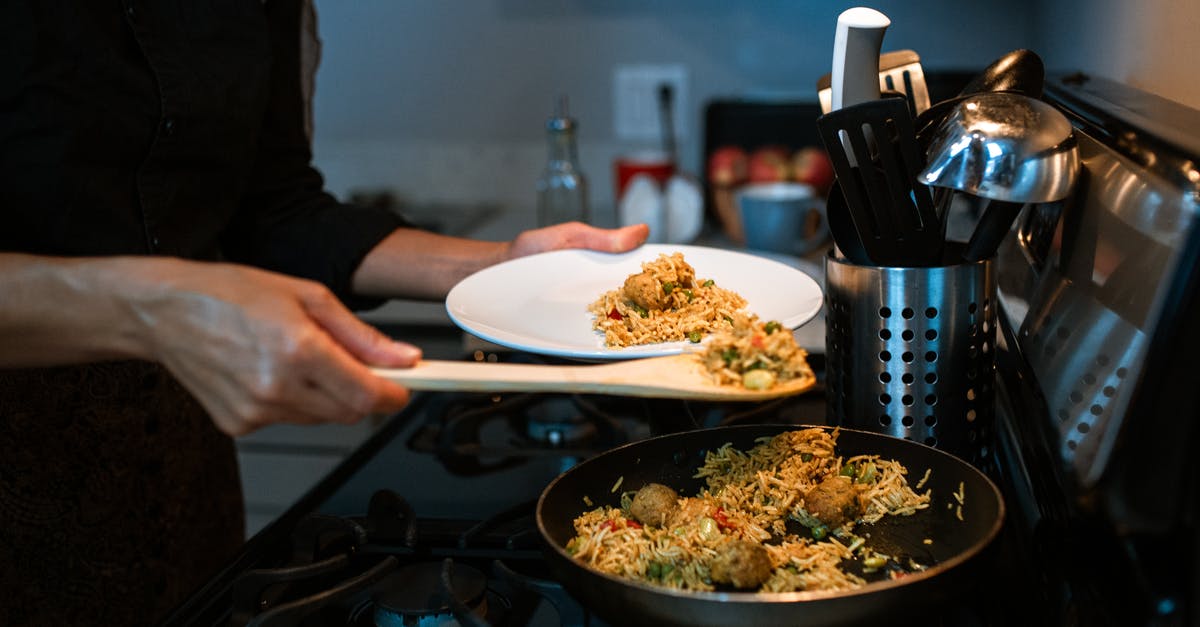 How to retain the saltiness and spicy flavour of biryani rice? - A Person Putting Fried Rice on a Plate