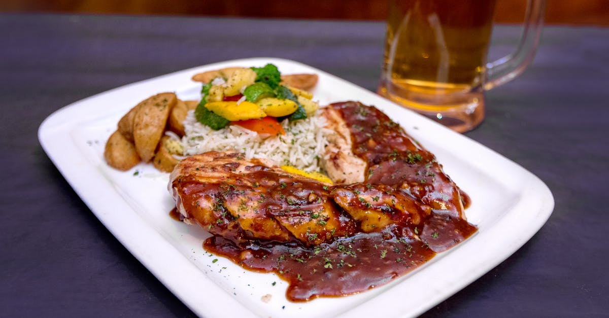 How to rice potatoes - From above of tasty grilled pork steak with barbecue sauce served with salad and fried potato on table near mug of beer
