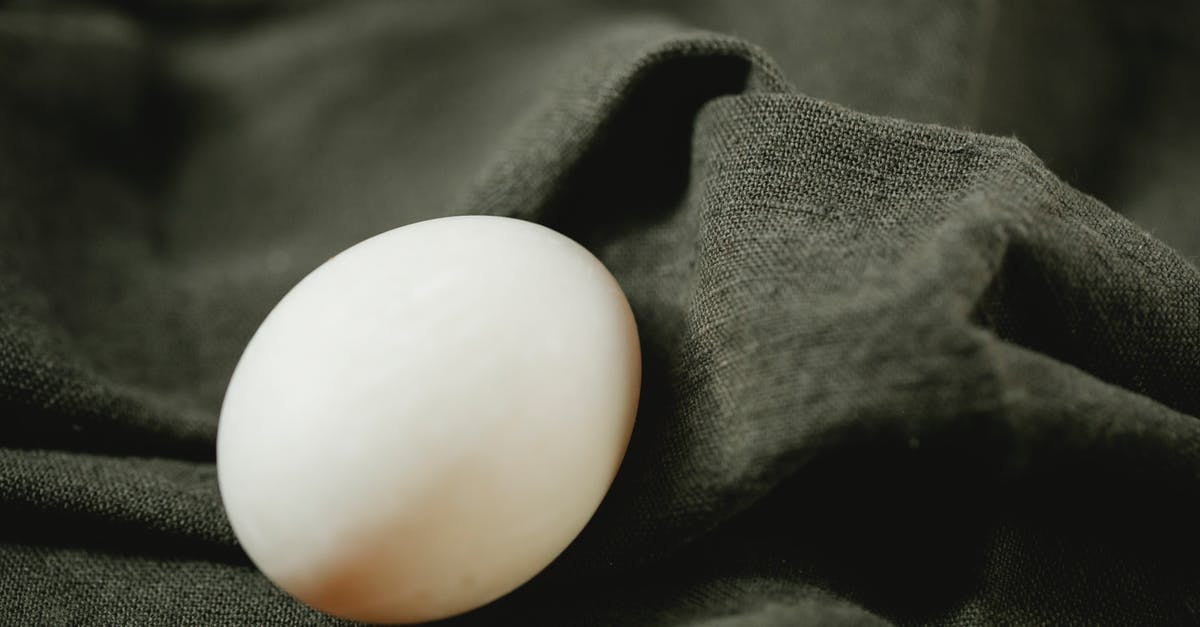 How to soft boil an egg - Composition of organic white chicken egg placed on black soft textile in bright light How to soft boil an egg - Composition of organic white chicken egg placed on black soft textile in bright light