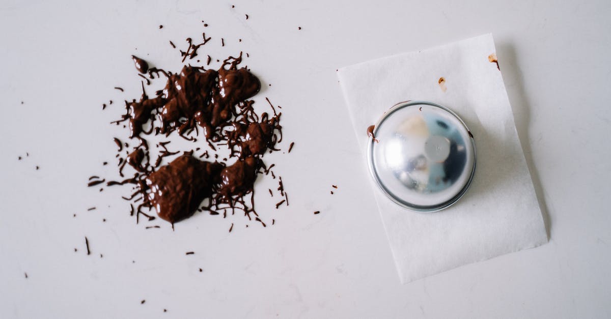 How to solidify melted chocolate? - Melted Chocolate on a White Surface Near a Metal Container How to solidify melted chocolate? - Melted Chocolate on a White Surface Near a Metal Container