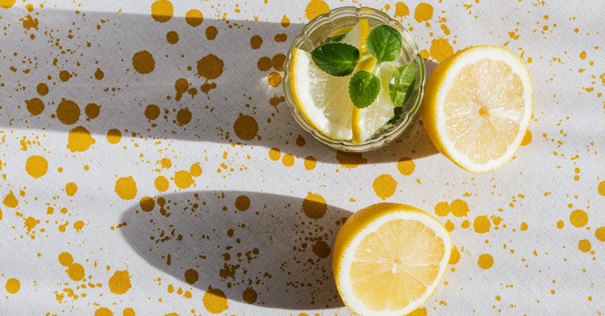 How to stop mint flavor dying when cooking? - Top view of glass of fresh cold drink with halves of lemon on table with white tablecloth in yellow blots How to stop mint flavor dying when cooking? - Top view of glass of fresh cold drink with halves of lemon on table with white tablecloth in yellow blots