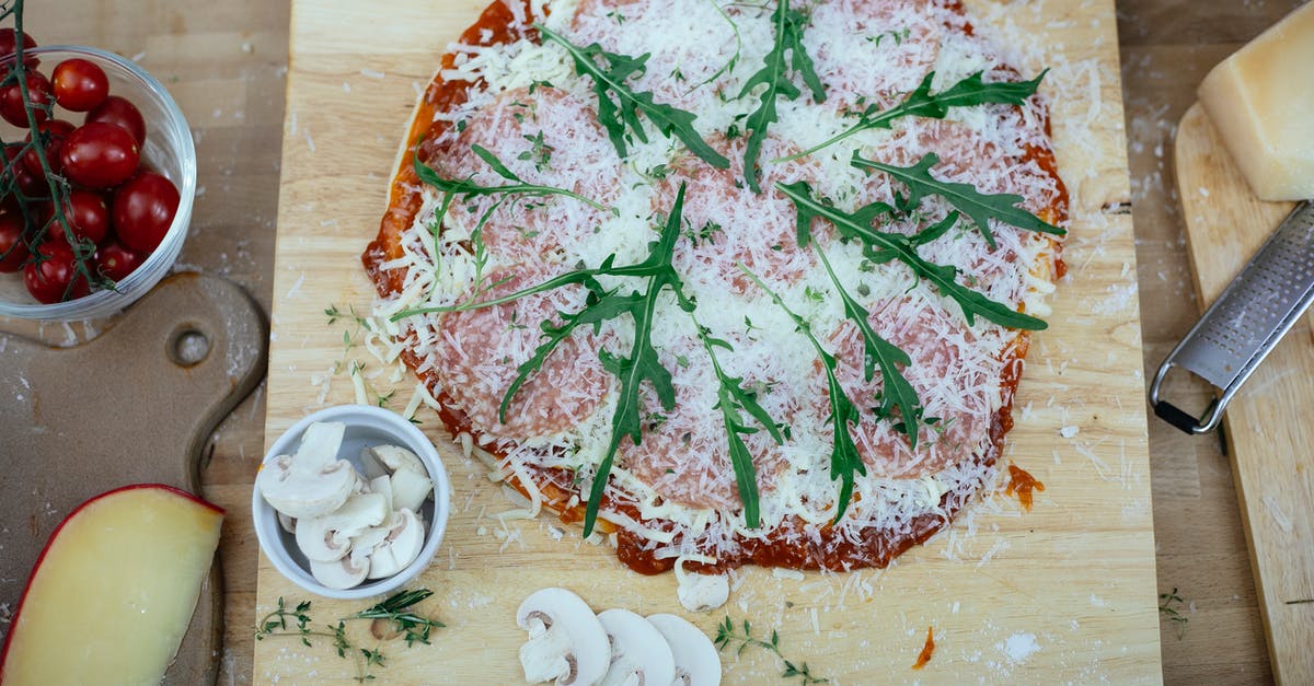 How to store homemade fresh Mozzarella Cheese - Uncooked pizza with herbs on kitchen table How to store homemade fresh Mozzarella Cheese - Uncooked pizza with herbs on kitchen table