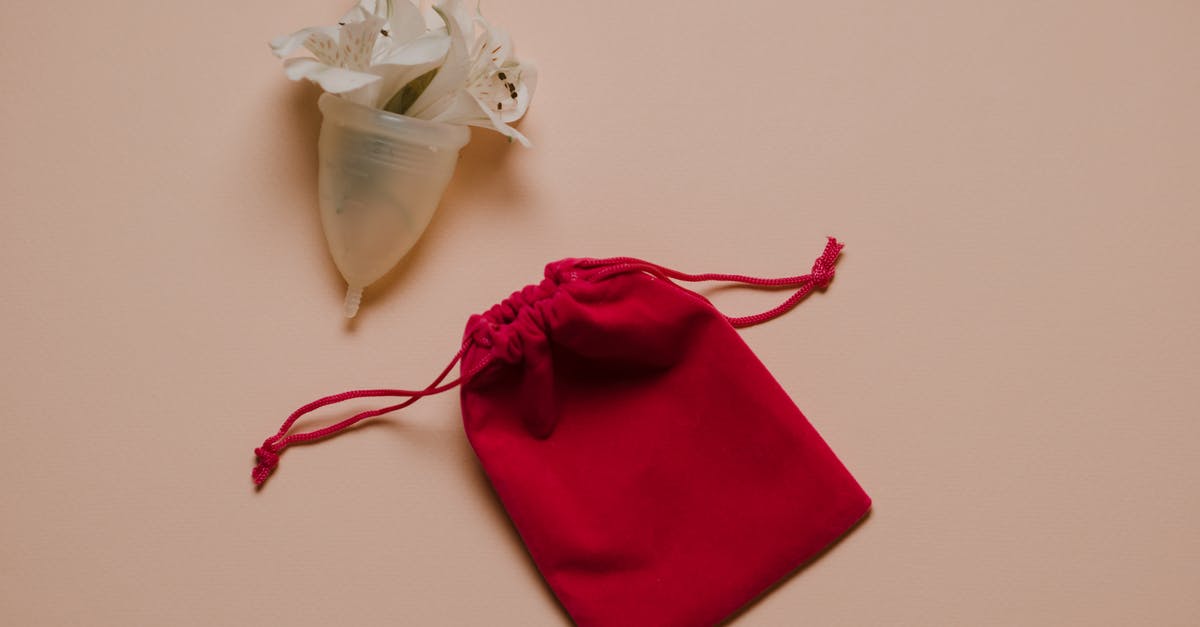How to take care of Silicone cookware - Menstrual cup with white gentle flowers placed on pink surface near bag How to take care of Silicone cookware - Menstrual cup with white gentle flowers placed on pink surface near bag