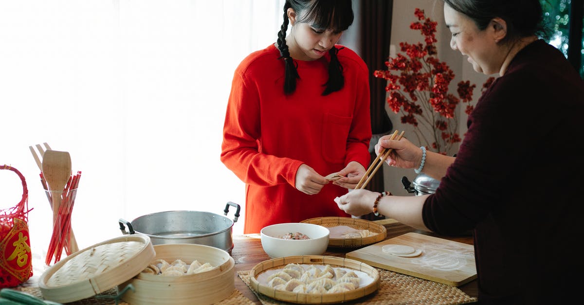 How to tell if a vegetable steamer contains titanium - Cheerful ethnic grandma with attentive teen preparing dumplings at table with traditional steamers during New Year holiday at home How to tell if a vegetable steamer contains titanium - Cheerful ethnic grandma with attentive teen preparing dumplings at table with traditional steamers during New Year holiday at home