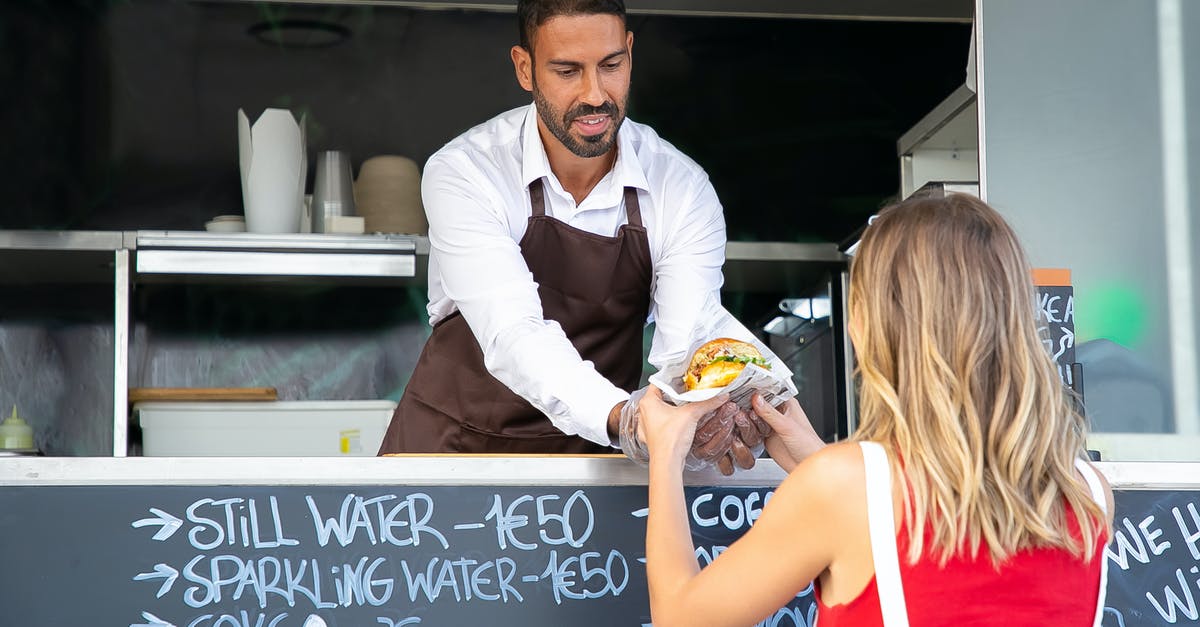 How to tell when a turkey burger is fully cooked? - Positive ethnic cook in apron standing at counter in food truck and giving delicious hamburger to anonymous woman customer in daytime How to tell when a turkey burger is fully cooked? - Positive ethnic cook in apron standing at counter in food truck and giving delicious hamburger to anonymous woman customer in daytime
