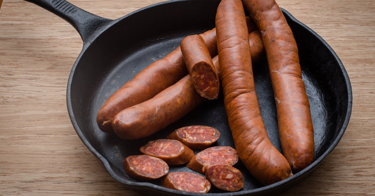 How to use a ridged cast iron griddle? - Tasty sausages in frying pan on table How to use a ridged cast iron griddle? - Tasty sausages in frying pan on table