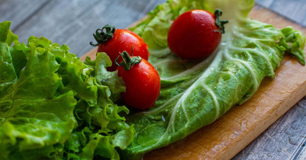 How to wash lettuce - From above of assorted varieties of lettuce leaves placed on wet wooden cutting board with ripe appetizing tomatoes in kitchen in daylight How to wash lettuce - From above of assorted varieties of lettuce leaves placed on wet wooden cutting board with ripe appetizing tomatoes in kitchen in daylight