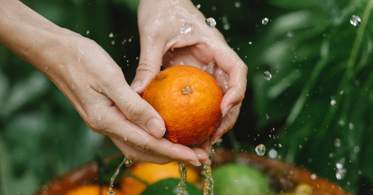 How to wash vegetables without running water? - Crop woman washing fresh citruses in tropical garden How to wash vegetables without running water? - Crop woman washing fresh citruses in tropical garden